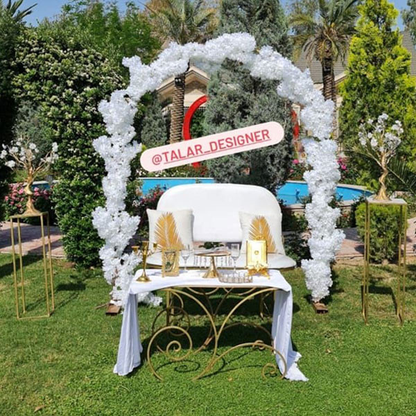 White Shade Wedding Decoration with Metallic Golden Color Table, Couch, 2 Tall Tables with Metallic Flowers, Gate Stand with Flowers, Candle Sticks, Glasses & Quran Book